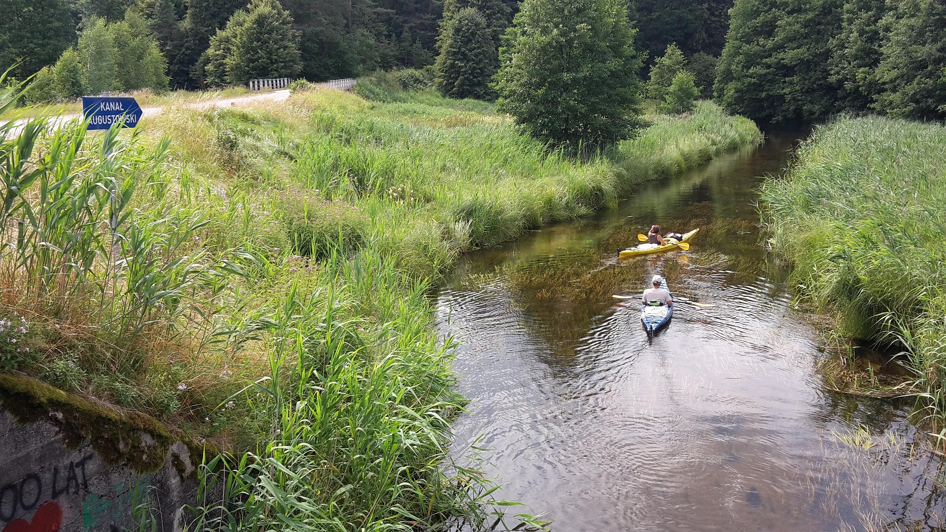 Bild zeigt zwei Kajaks auf einem kleinen Fluss im Inland.